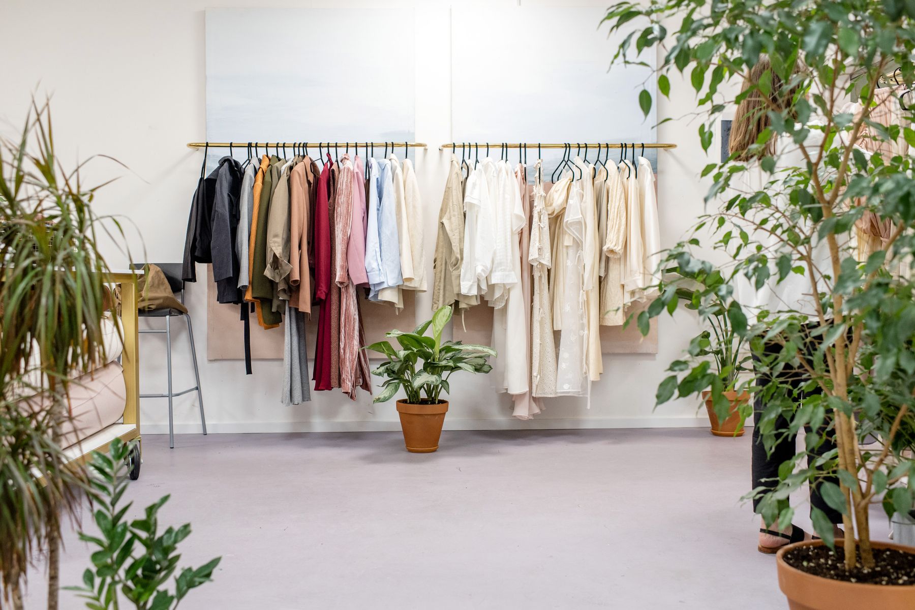 Clothing rail and folded garments in a bright boutique retail store