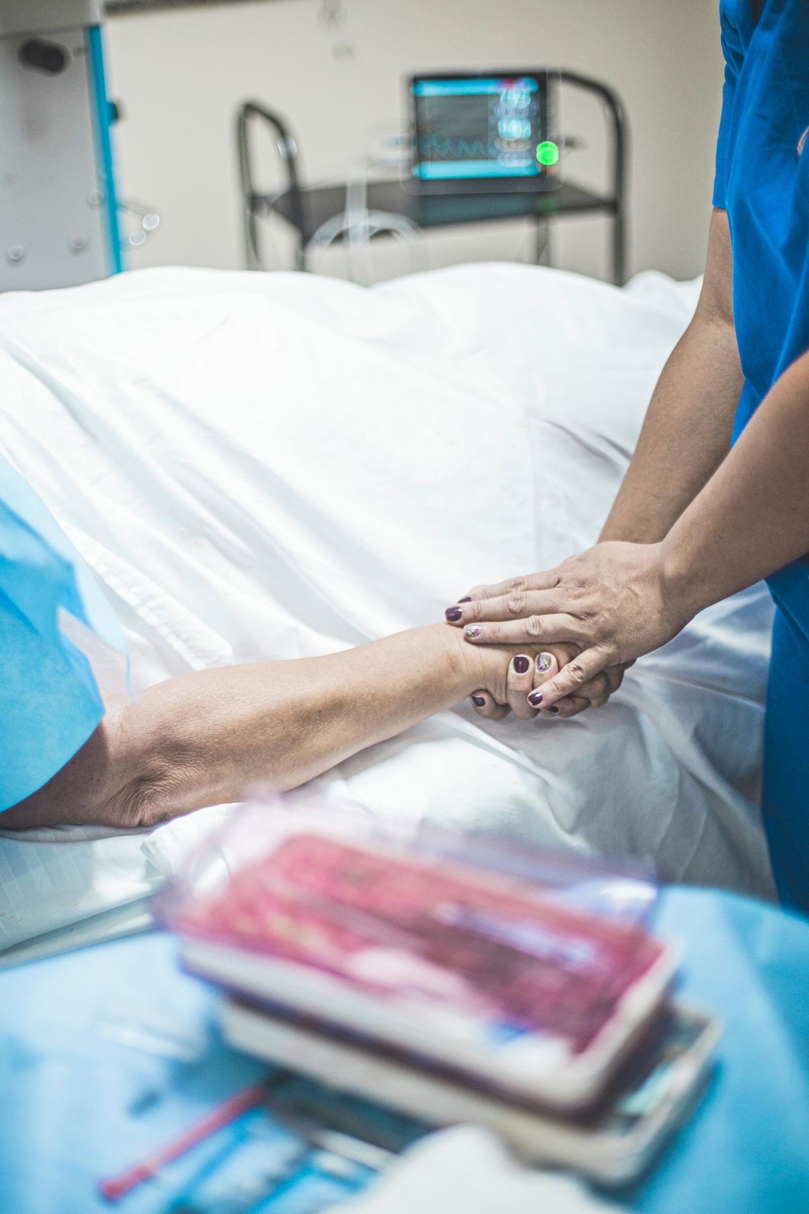 Clinician speaking with family members beside a patient in a hospital room