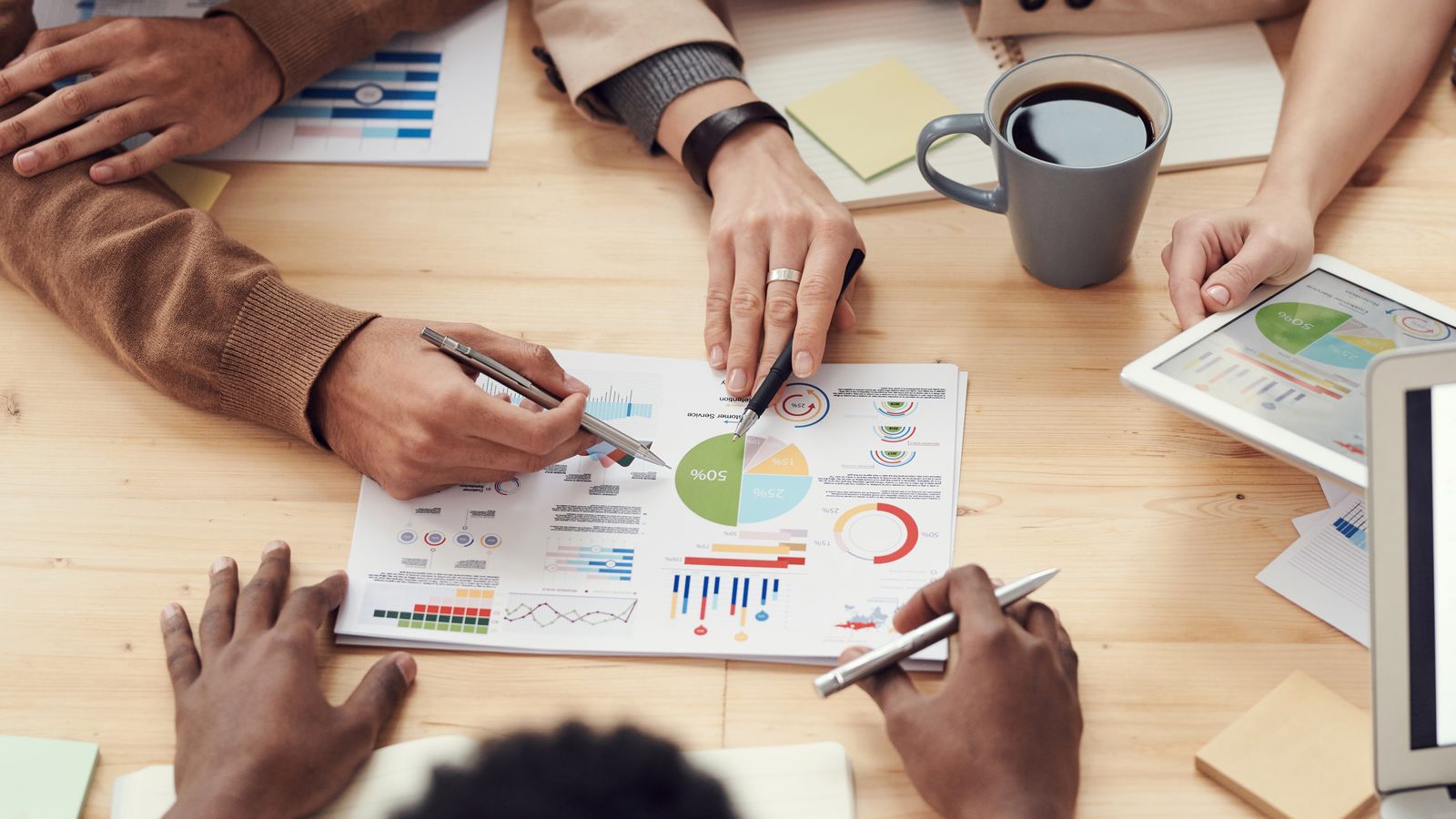 Founders reviewing printed product metrics and charts around a table
