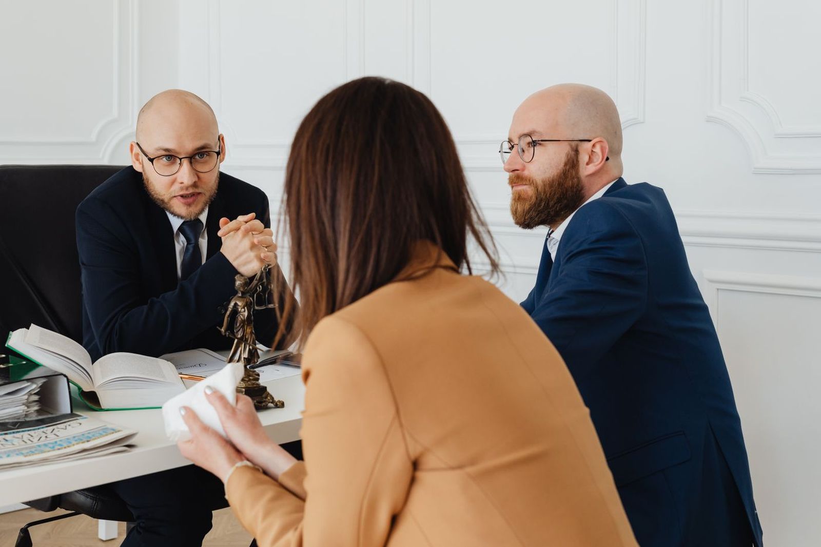 Immigration consultant discussing an application with a couple across an office desk
