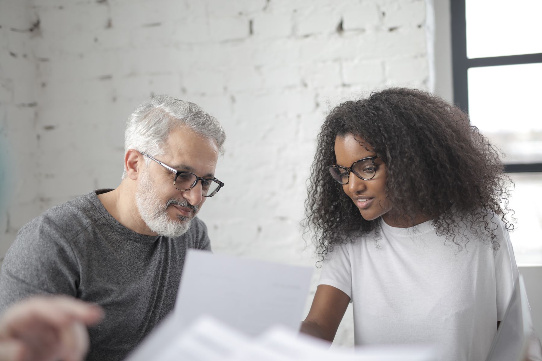 A coach and client reviewing notes together across a table