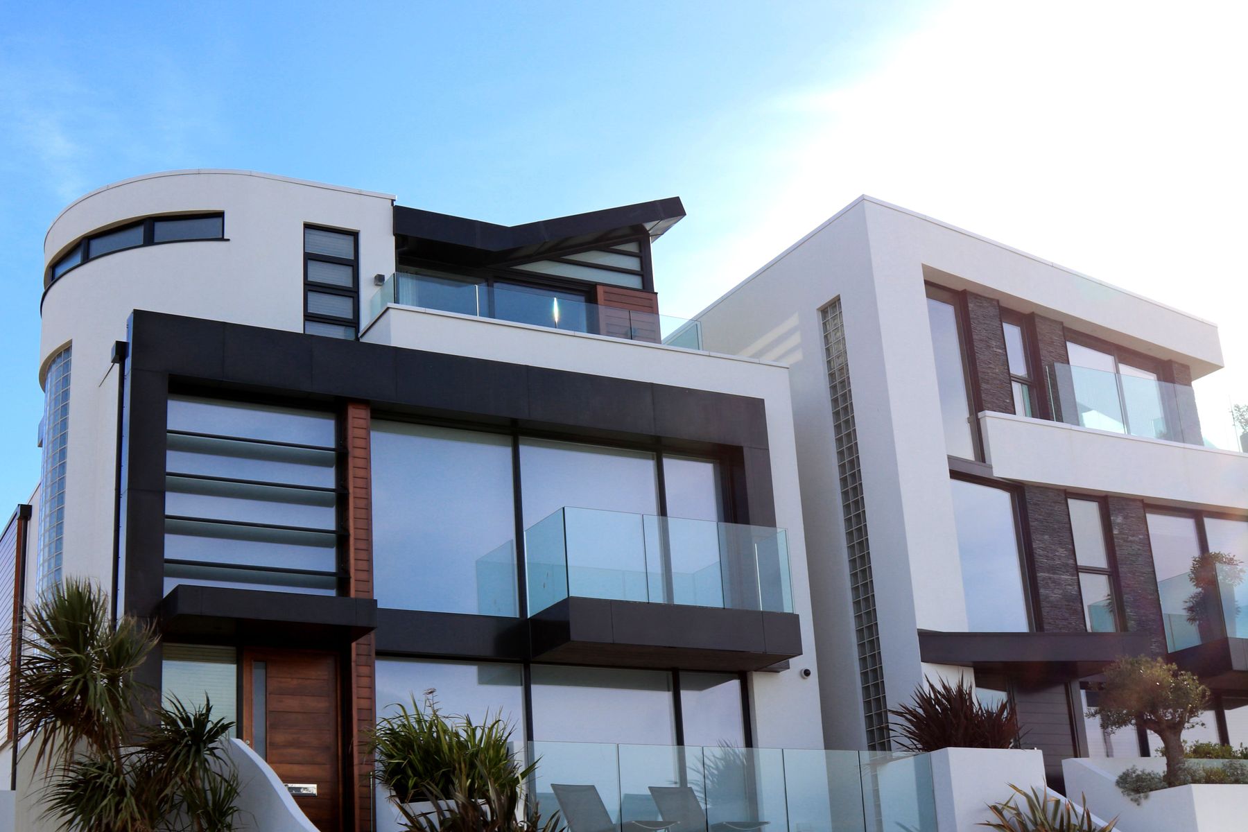 Modern multi level residential building exterior with glazing, timber cladding and balconies