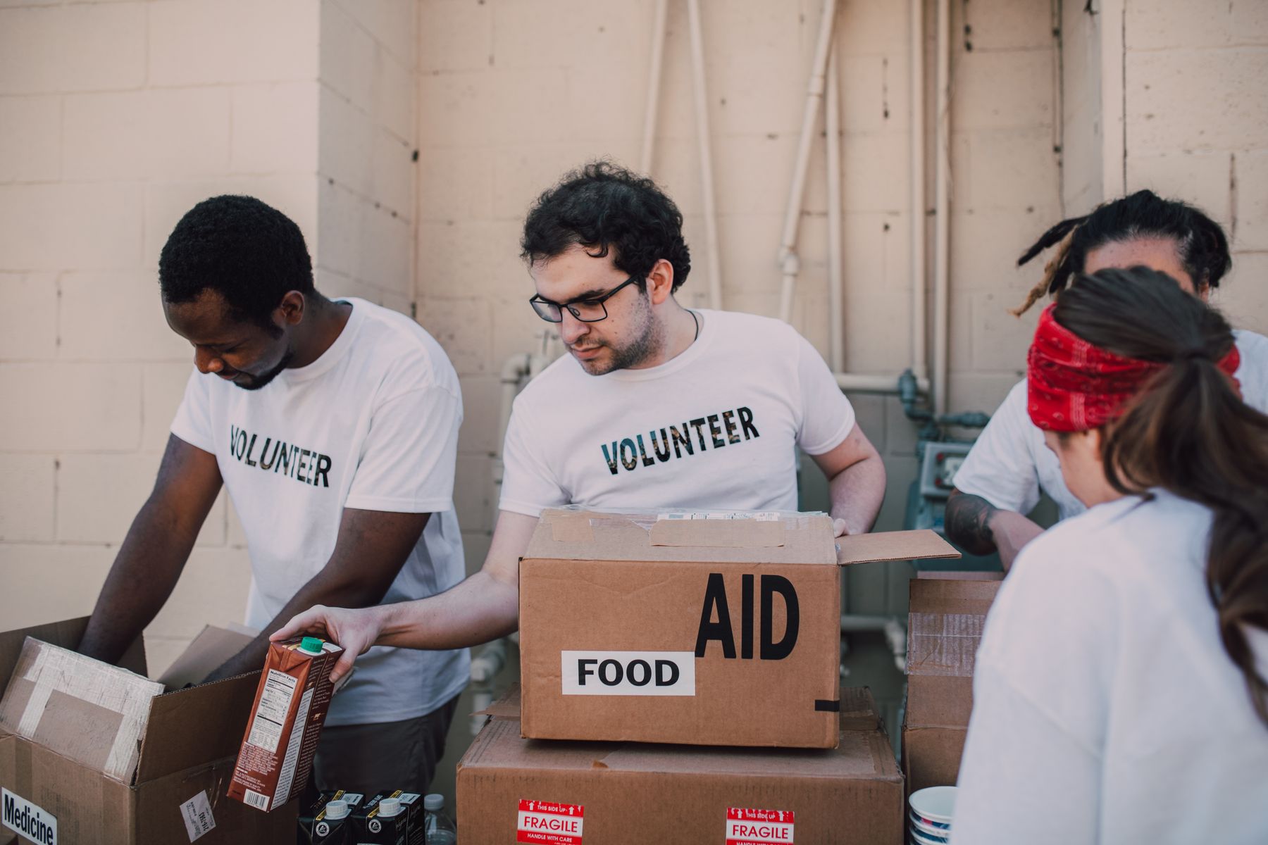 Volunteers in branded shirts packing boxes of food and aid supplies at a charity drive
