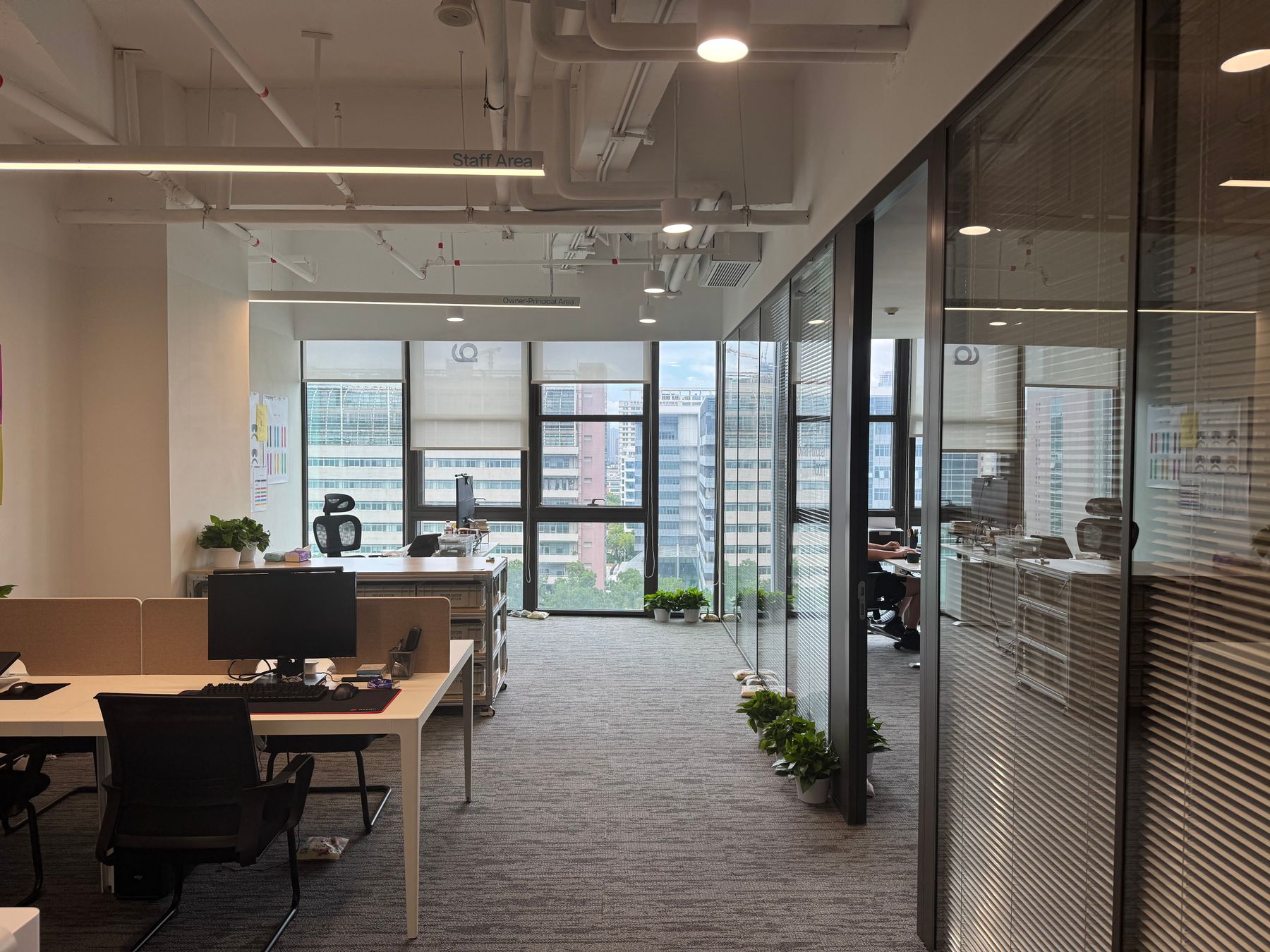 Open plan office floor with desks, glazed partitions and full height windows