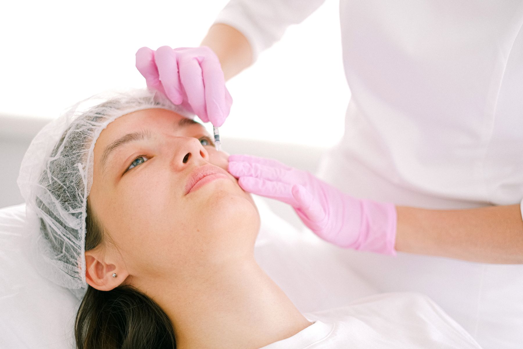 Practitioner carrying out a skin treatment for a client in a clinic treatment room