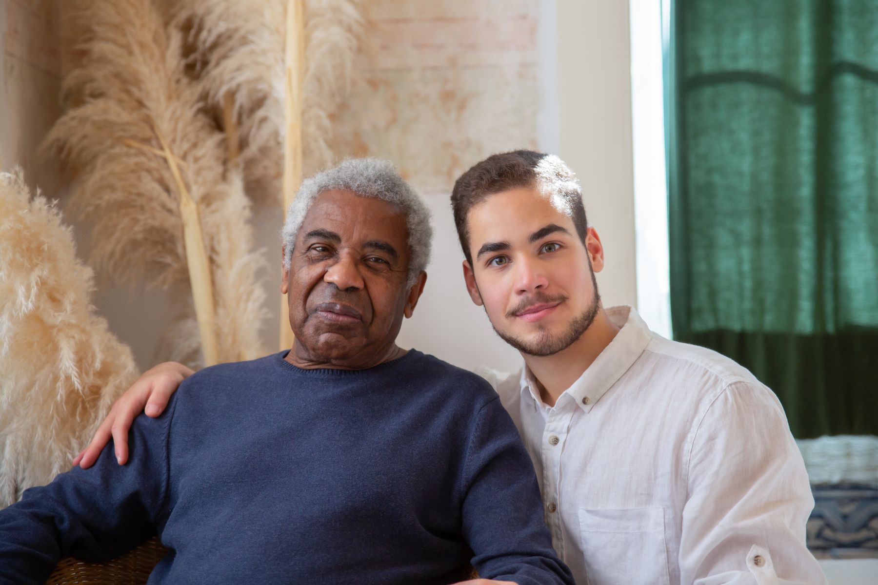Support worker sitting with an older man in his home during a support visit