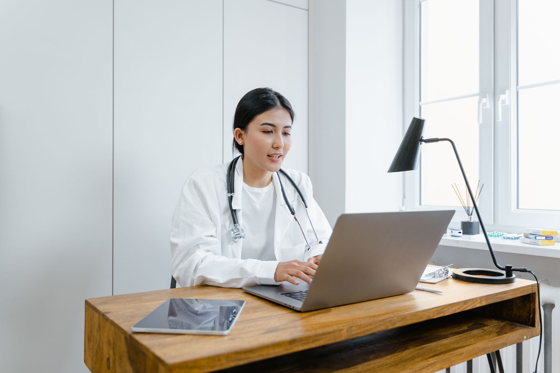 Clinician working at a desk in a bright consulting room