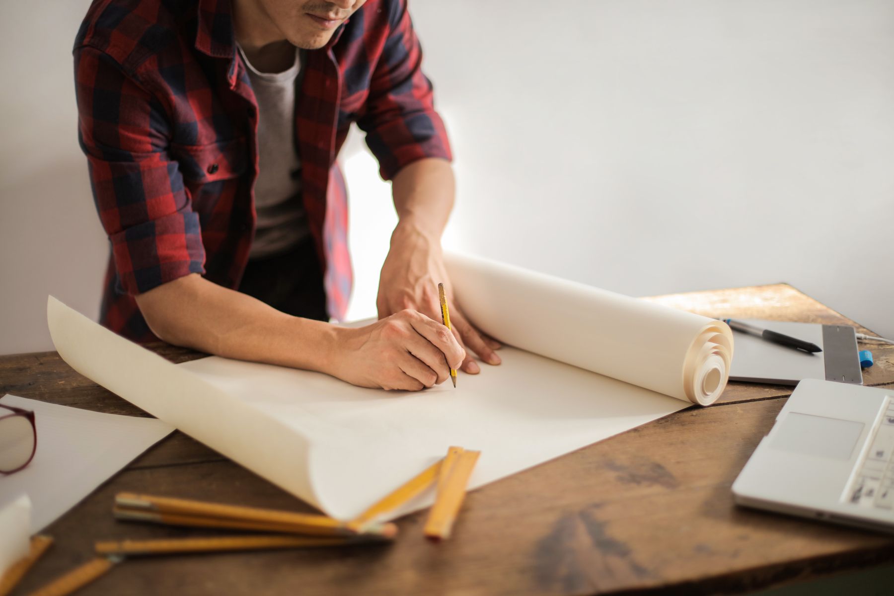 Rolled technical drawings and design tools laid out on an engineering desk