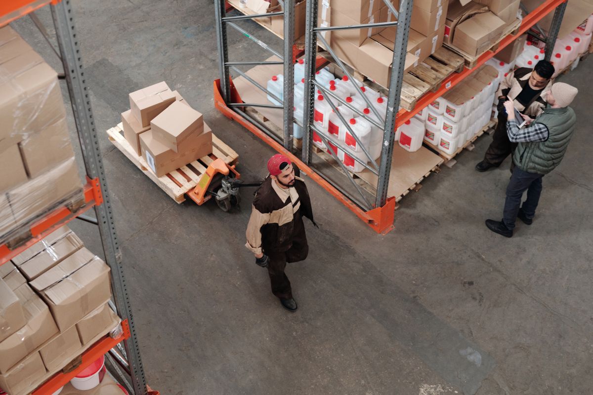 Warehouse staff moving pallets between racking bays